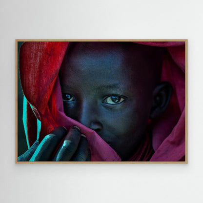Ethiopian child covered in a red robe. by Joxe Inazio Kuesta Garmendia