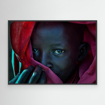 Ethiopian child covered in a red robe. by Joxe Inazio Kuesta Garmendia